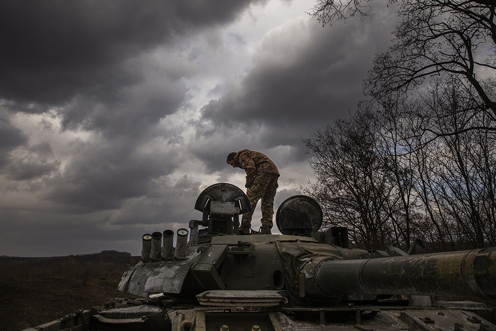 Ukrainian soldier examines a Russian tank