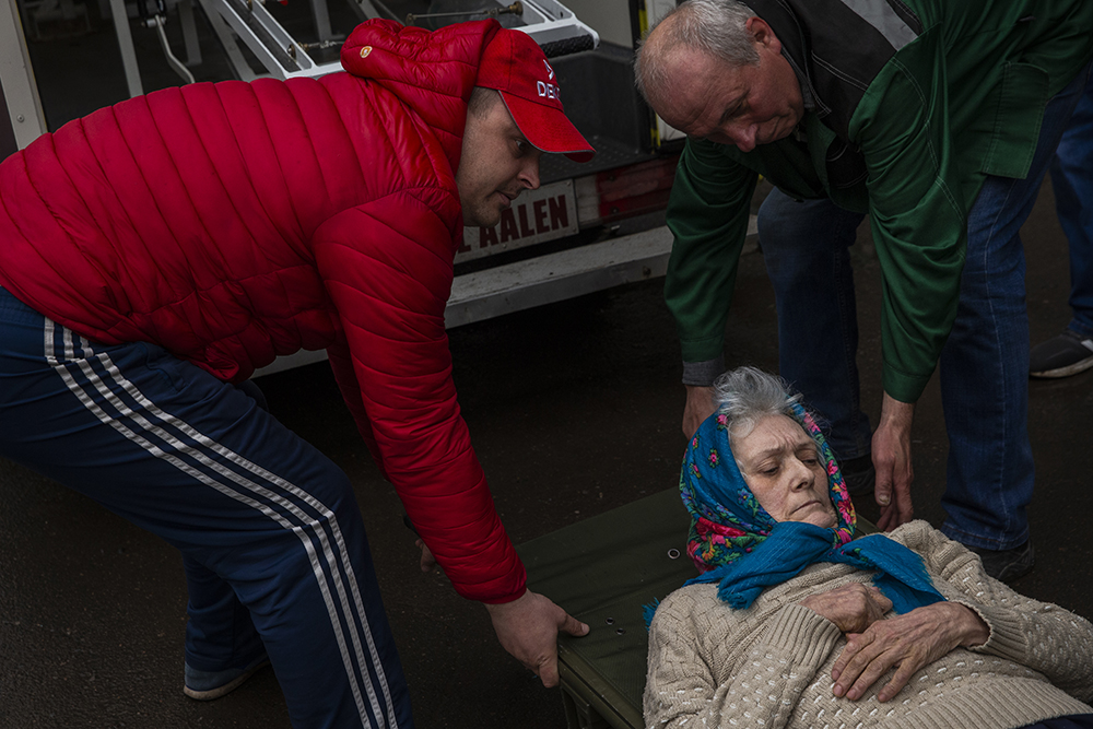 An elderly woman being lifted into an evacuation vehicle at a care center in  Toretsk