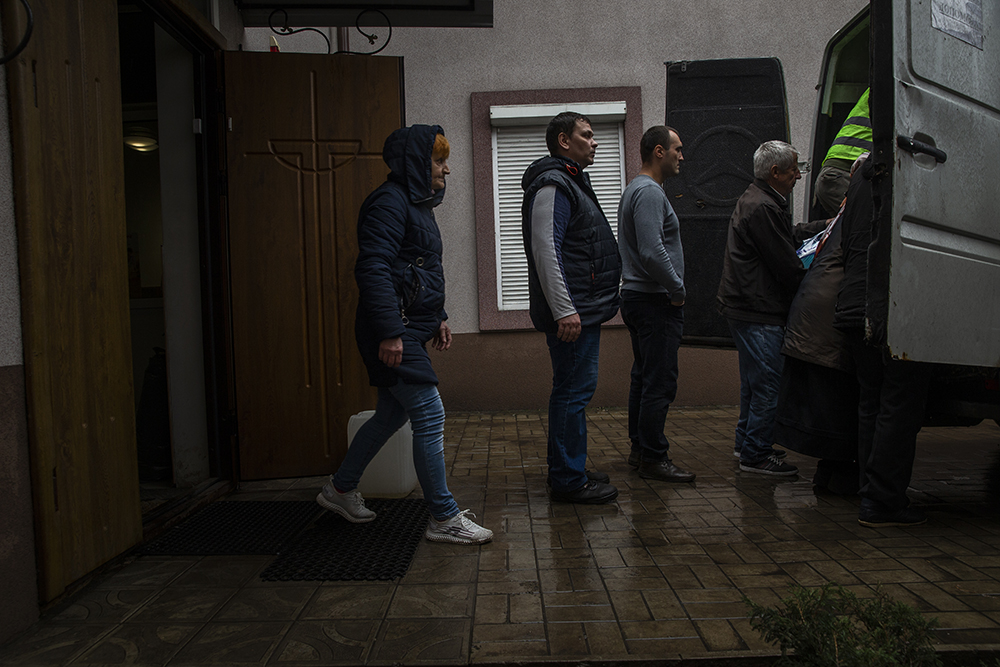 People remove supplies at a church housing elderly people  in Pokrovsk