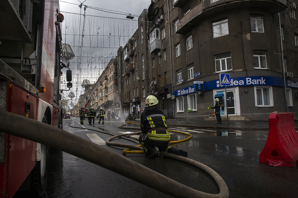 Firefighters work to extinguish a building set ablaze by Russian shelling Kharkiv on Easter Sunday